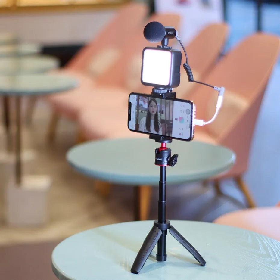 Folded mobile phone vlog bracket with built-in fill light next to a smartphone