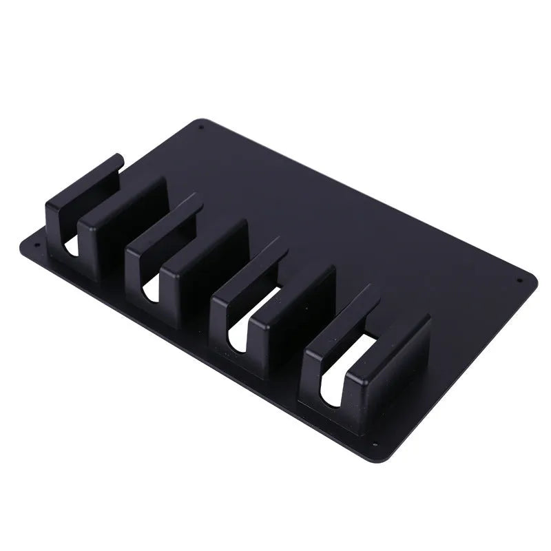 Black plastic wall-mounted frame holding four hair clippers