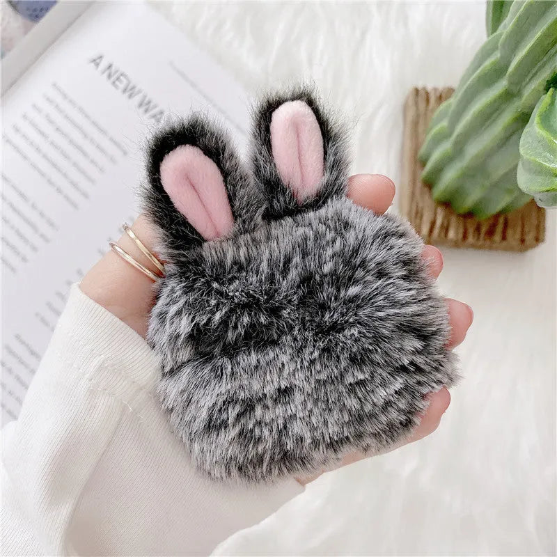 Pink silicone AirPods protective case with plush rabbit ears on charging case