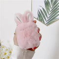 Pink silicone AirPods protective case with plush rabbit ears on charging case