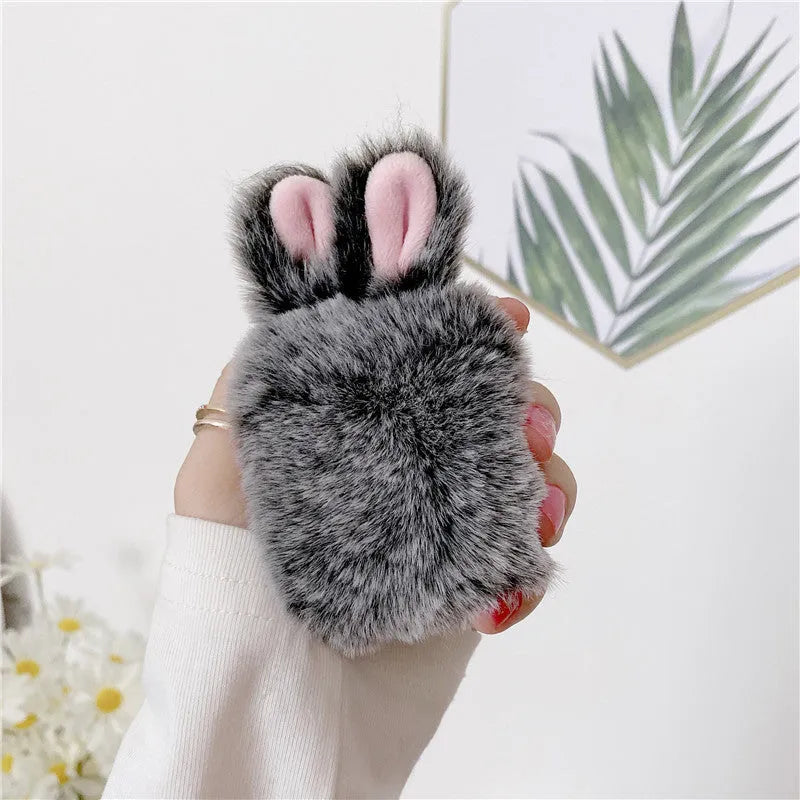 Pink silicone AirPods protective case with plush rabbit ears on charging case