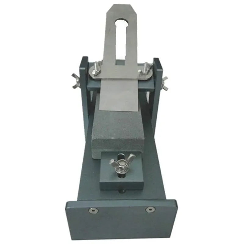 Aluminium alloy gantry fixed angle sharpening tool for woodworking chisels and planers on a workbench.