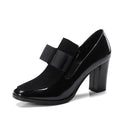 Black patent leather women's high heels with a thick square heel and square toe on a rubber sole.