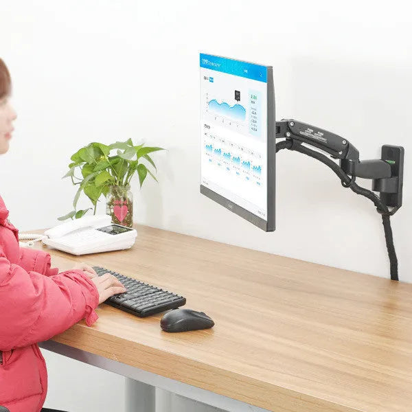 Black wall-mounted adjustable monitor stand extended from the wall, showing VESA plate.