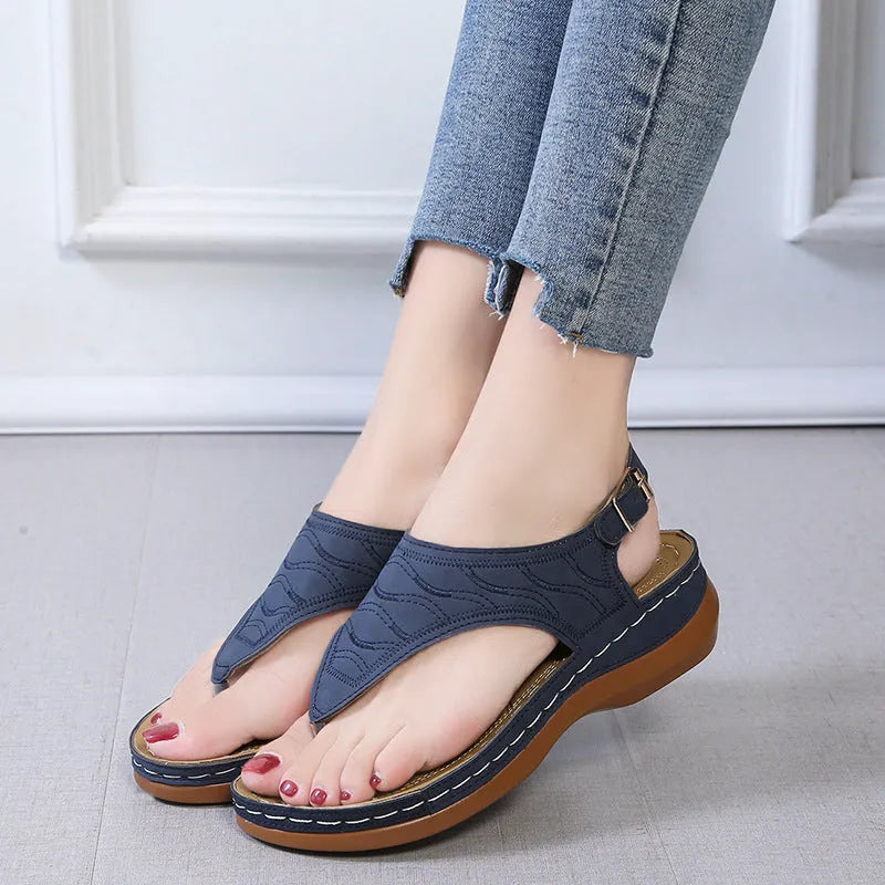 Women's wedge heel flip flop sandals in black with an adjustable back strap and buckle.