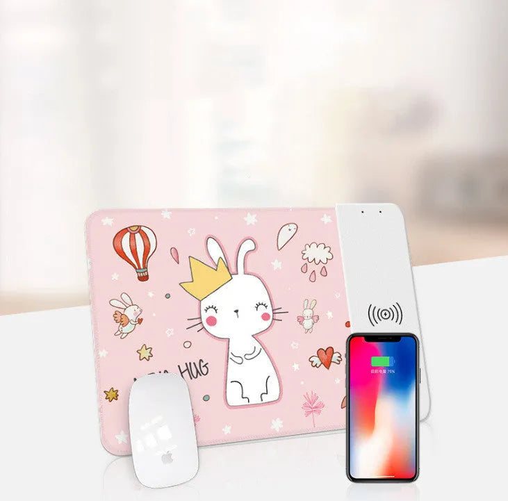 Wireless charging mouse pad with RGB edge lighting and cartoon graphic on black cloth surface.