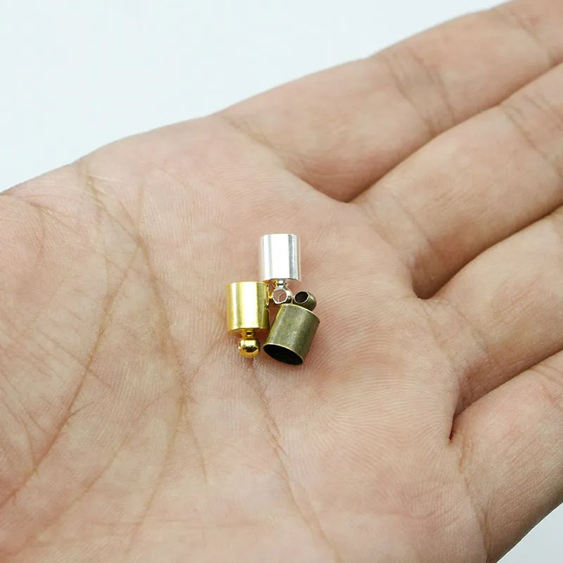 Assorted copper bell caps in gold, silver, and bronze finishes for jewellery making.