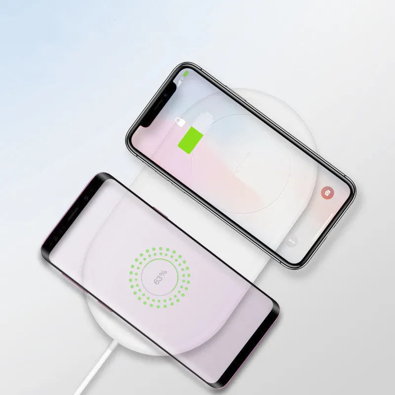 White dual wireless phone charger showing two phones charging simultaneously on minimalist charging pad
