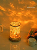 Small rotating water ripple effect night light with a solid wood base on a table
