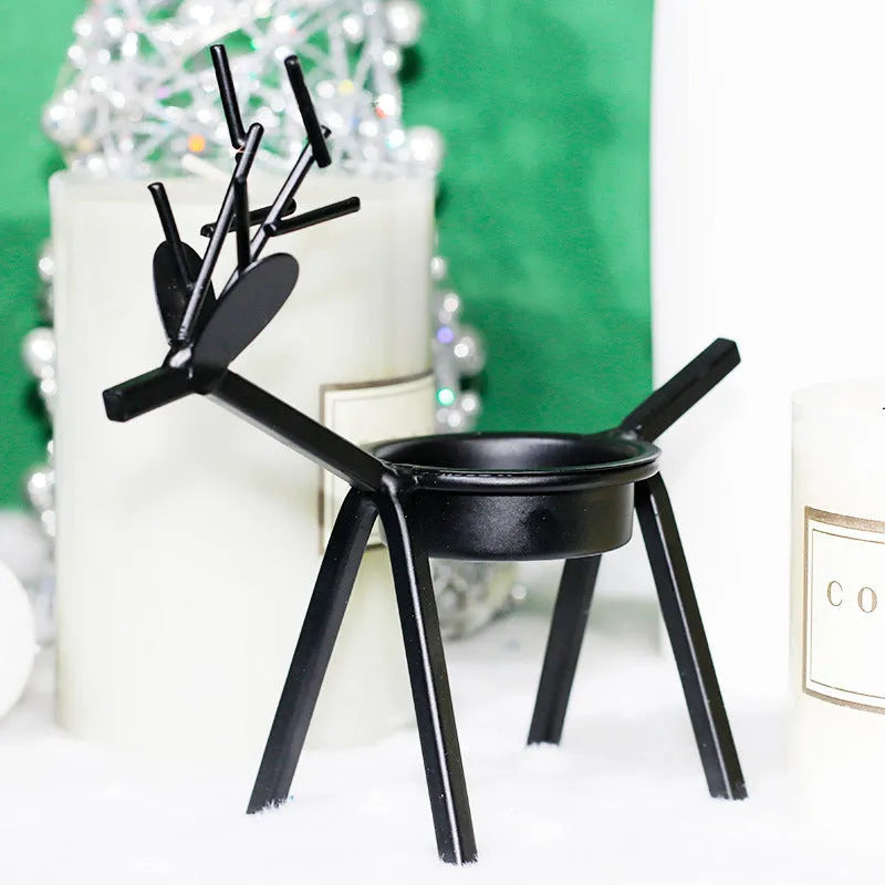 Black iron elk Christmas candlestick holder on table with candle