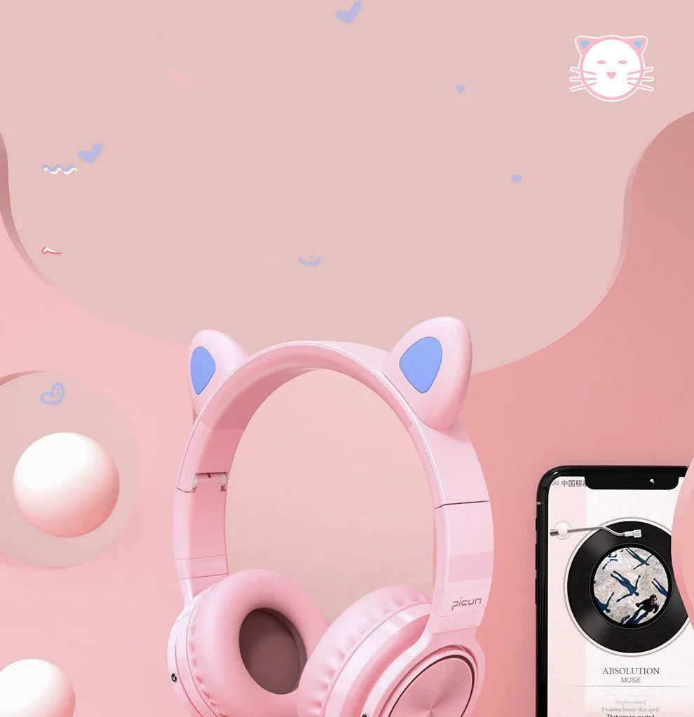Pink and white wireless Bluetooth over-ear headset with a braided cable on a grey background.