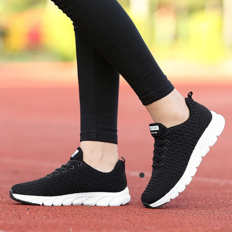 Women's running shoes with Fly Knit woven upper in Black, Pink, or White colour options