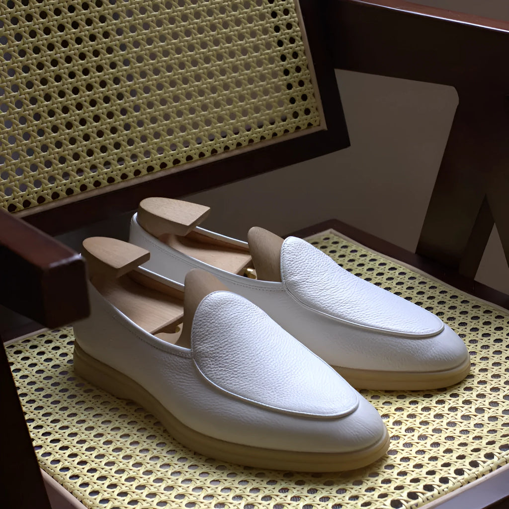 Men's brown handmade leather loafers with a flat TPR sole on a white background.