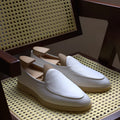 Men's brown handmade leather loafers with a flat TPR sole on a white background.