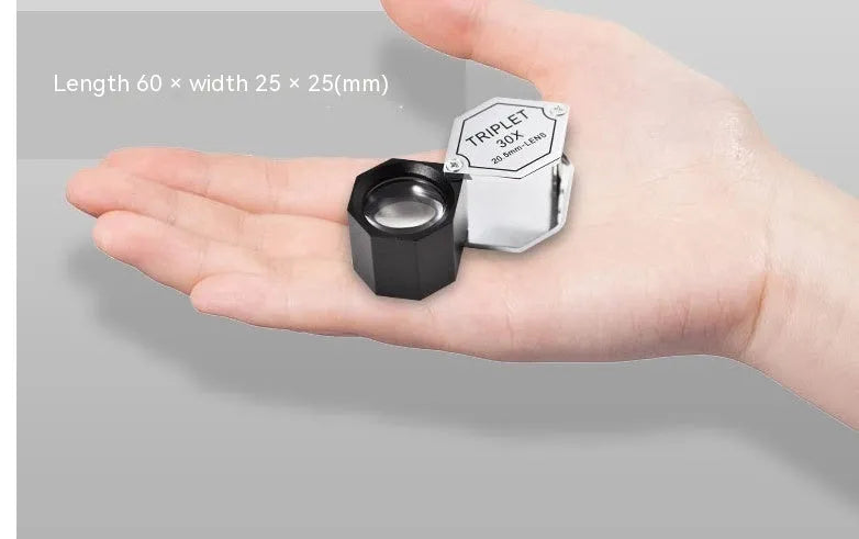 Handheld metal magnifying glass with optical glass lens for jewellery, stamp, and coin identification.