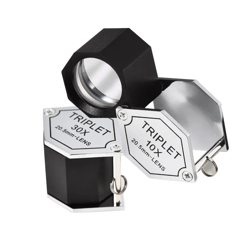 Handheld metal magnifying glass with optical glass lens for jewellery, stamp, and coin identification.