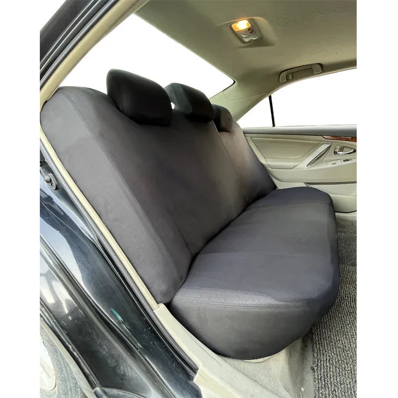 Blue polyester car seat cover with eyelet stitching on a car seat, showing front and headrest pieces.