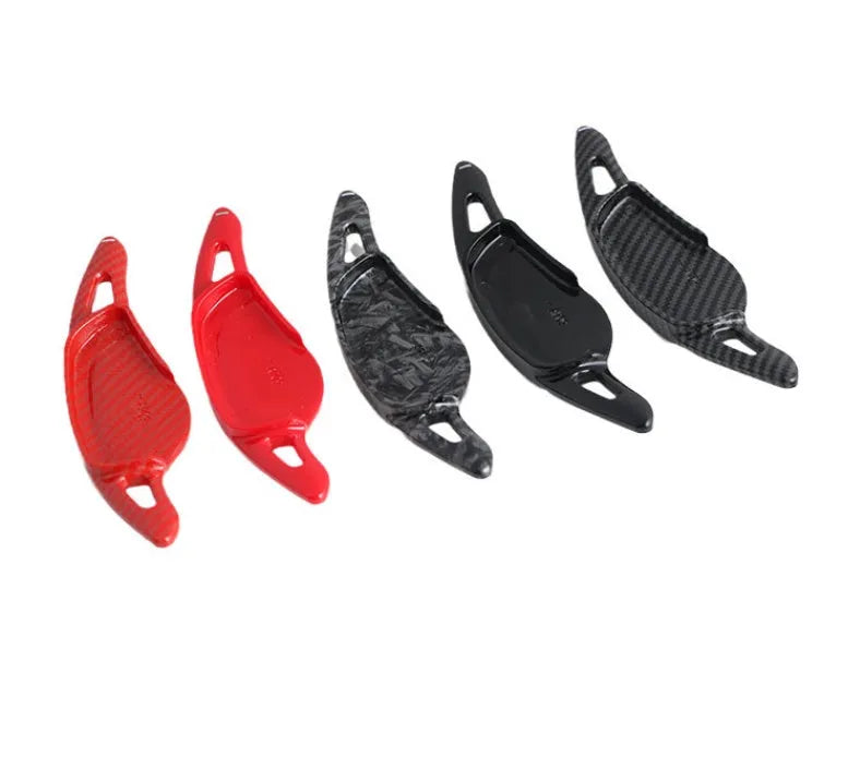 Steering wheel shift paddle modification kit in ABS plastic showing carbon fibre black and red finish options.
