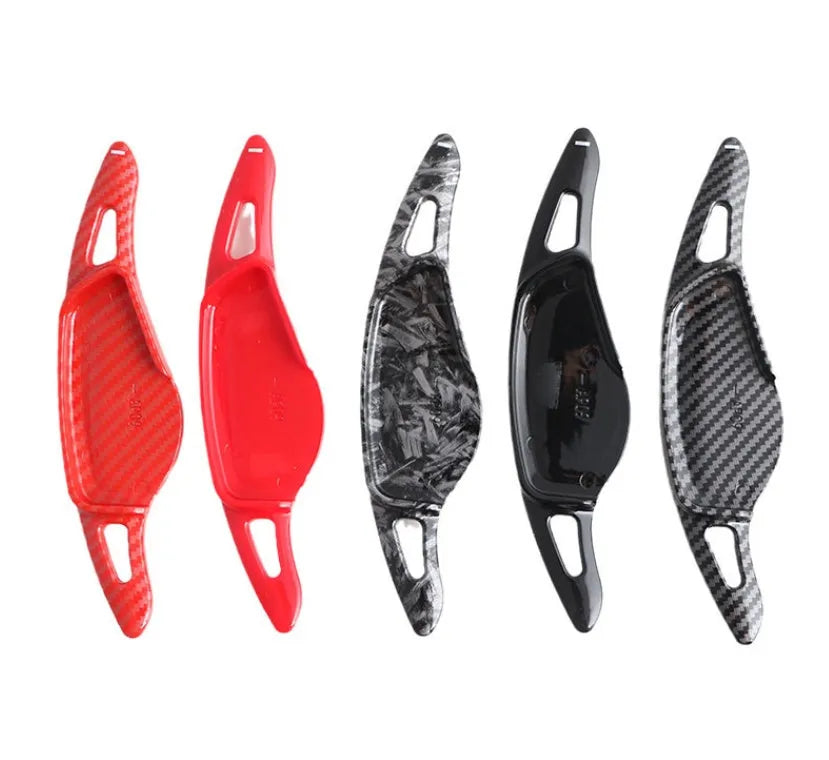 Steering wheel shift paddle modification kit in ABS plastic showing carbon fibre black and red finish options.