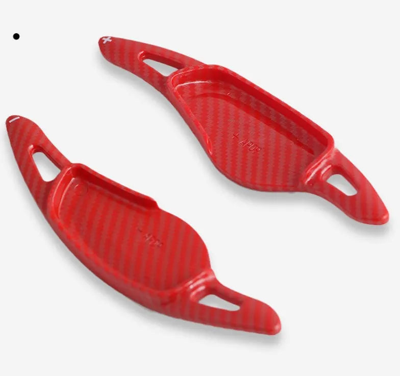 Steering wheel shift paddle modification kit in ABS plastic showing carbon fibre black and red finish options.