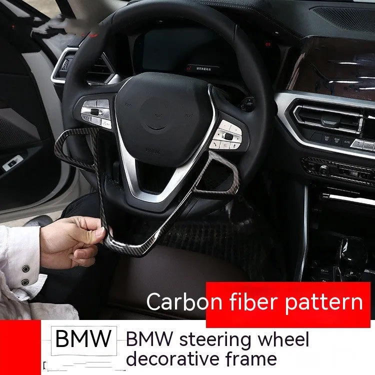 BMW steering wheel button frame decoration with black carbon fibre pattern finish.