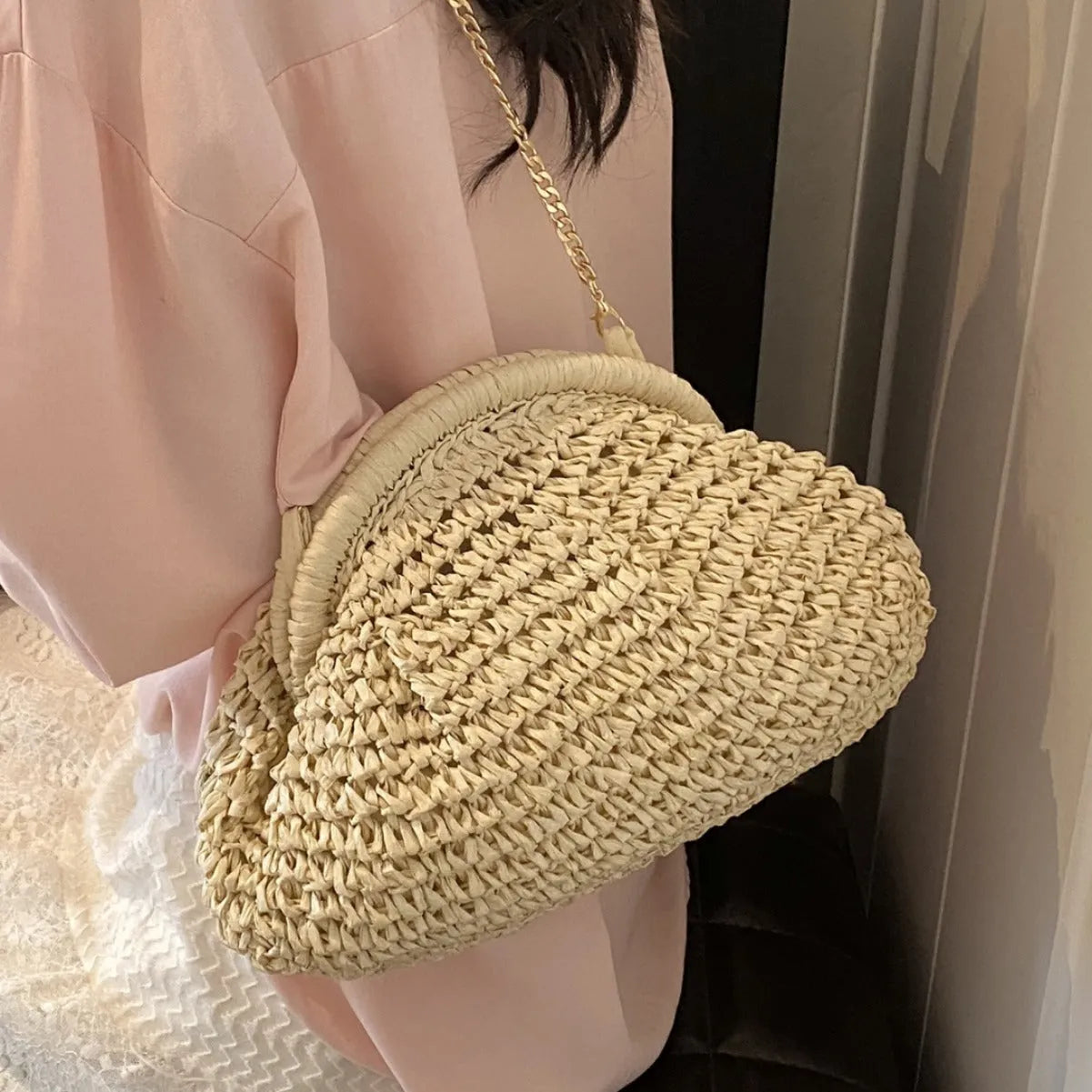 Shell-shaped straw beach bag with chain strap in khaki colour showing zippered pocket