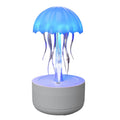 White jellyfish-shaped humidifier and essential oil diffuser with colourful LED lights on a desk.