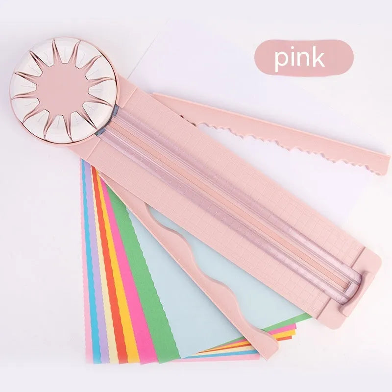 Pink plastic 12-in-1 paper cutting machine with dotted perforation wheel on craft table