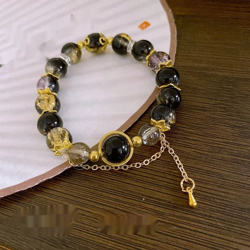 A Chinese style glass bracelet with bamboo leaf and bead designs on a wrist.