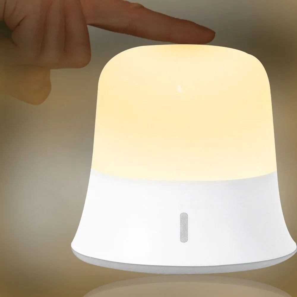 White touch-control baby night light with motion sensor on a nursery bedside table.