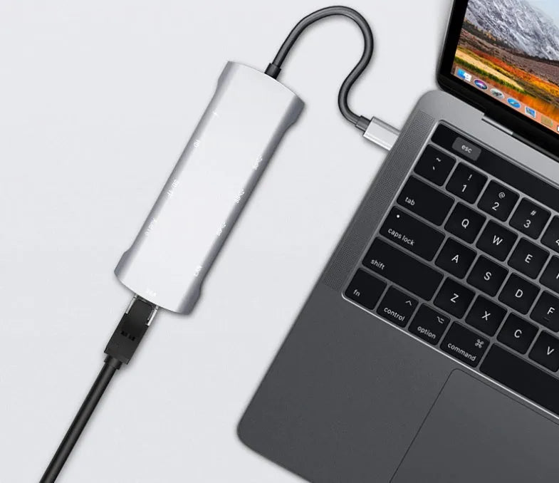 Grey aluminium USB-C docking station with HDMI, VGA, USB ports, and a short connecting cable