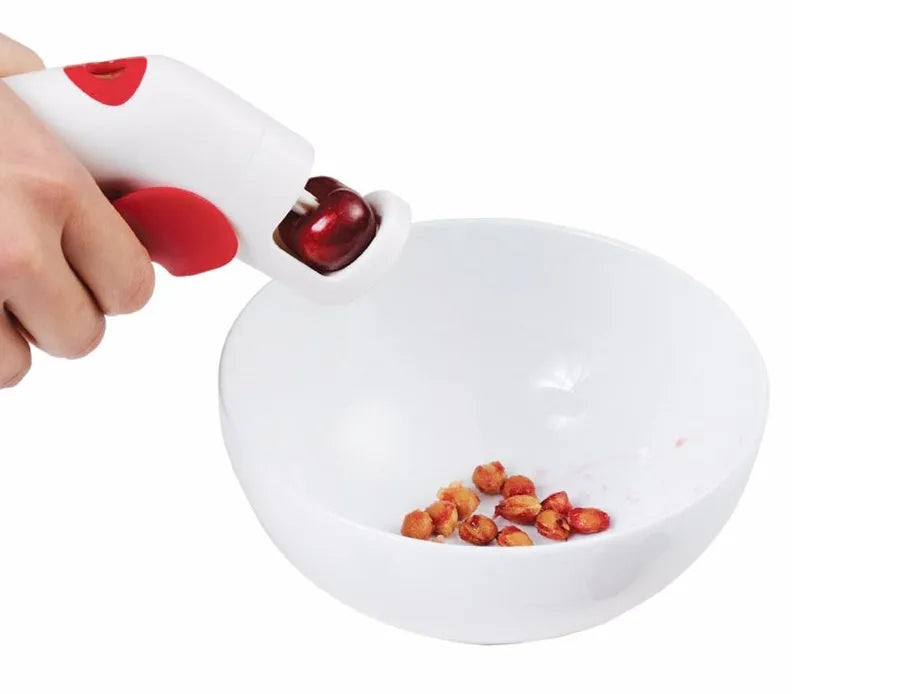 A manual cherry kernel remover kitchen tool with a handle for pitting cherries