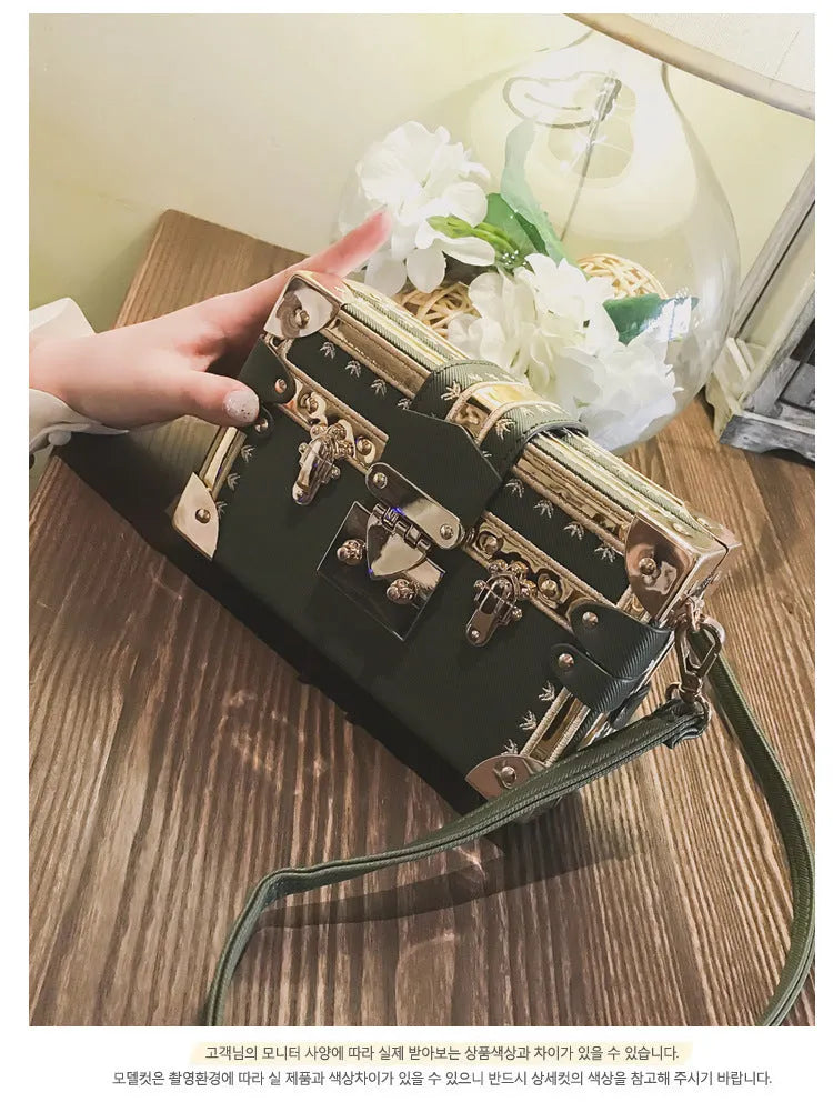 Hard-sided black PU leather women's shoulder bag with flap and decorative rivets.