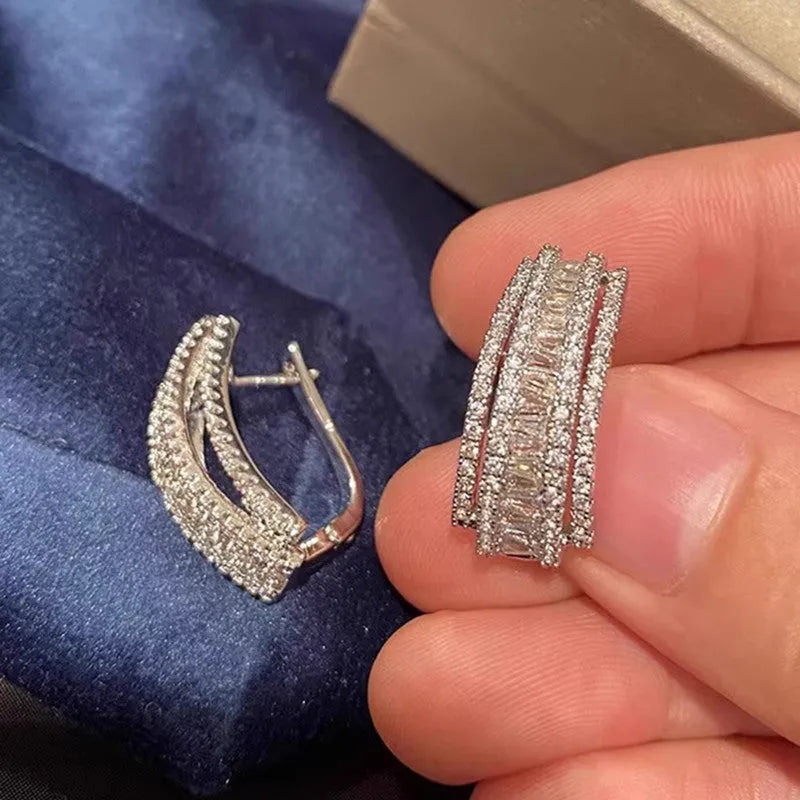 A pair of women's geometric stud earrings with inlaid zircon detail in a white gold colour.