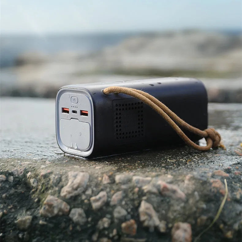 Black portable power bank with solar panel and display, showing 200W output and charging ports.
