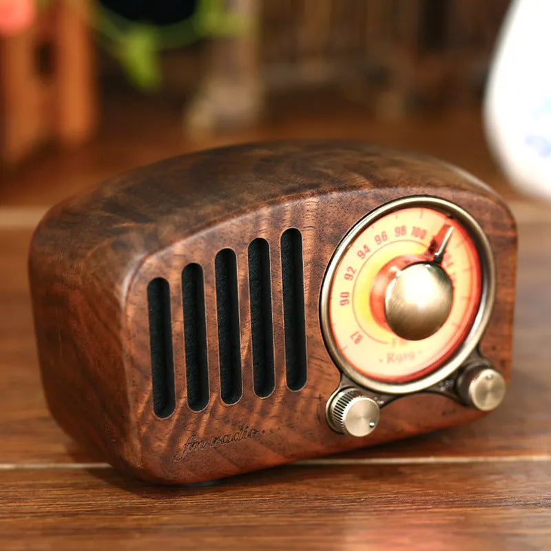 Compact retro wooden Bluetooth mini speaker in cherry wood finish showing front grille and wood grain.