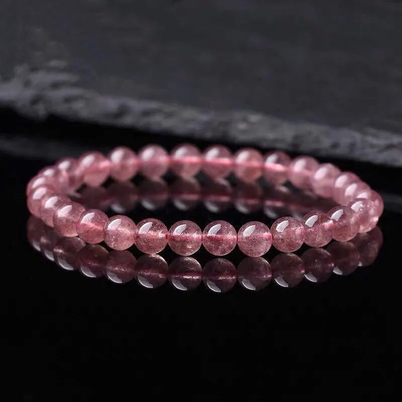 Women's strawberry quartz crystal bracelet with polished round beads.
