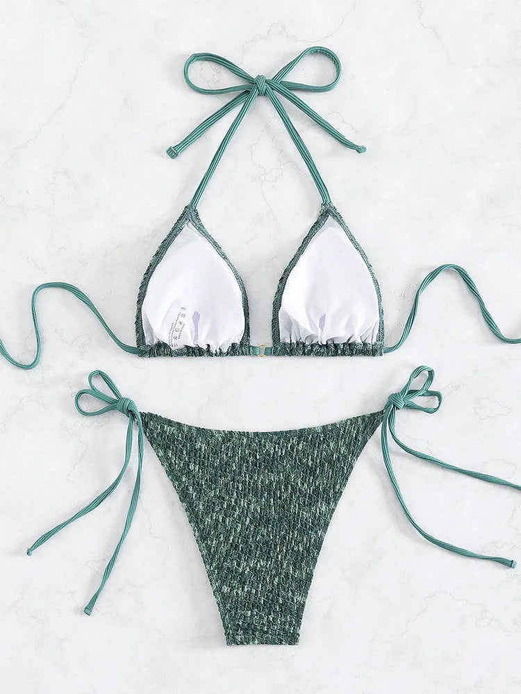 Green women's backless halter strap bikini set with matching shorts on a mannequin.