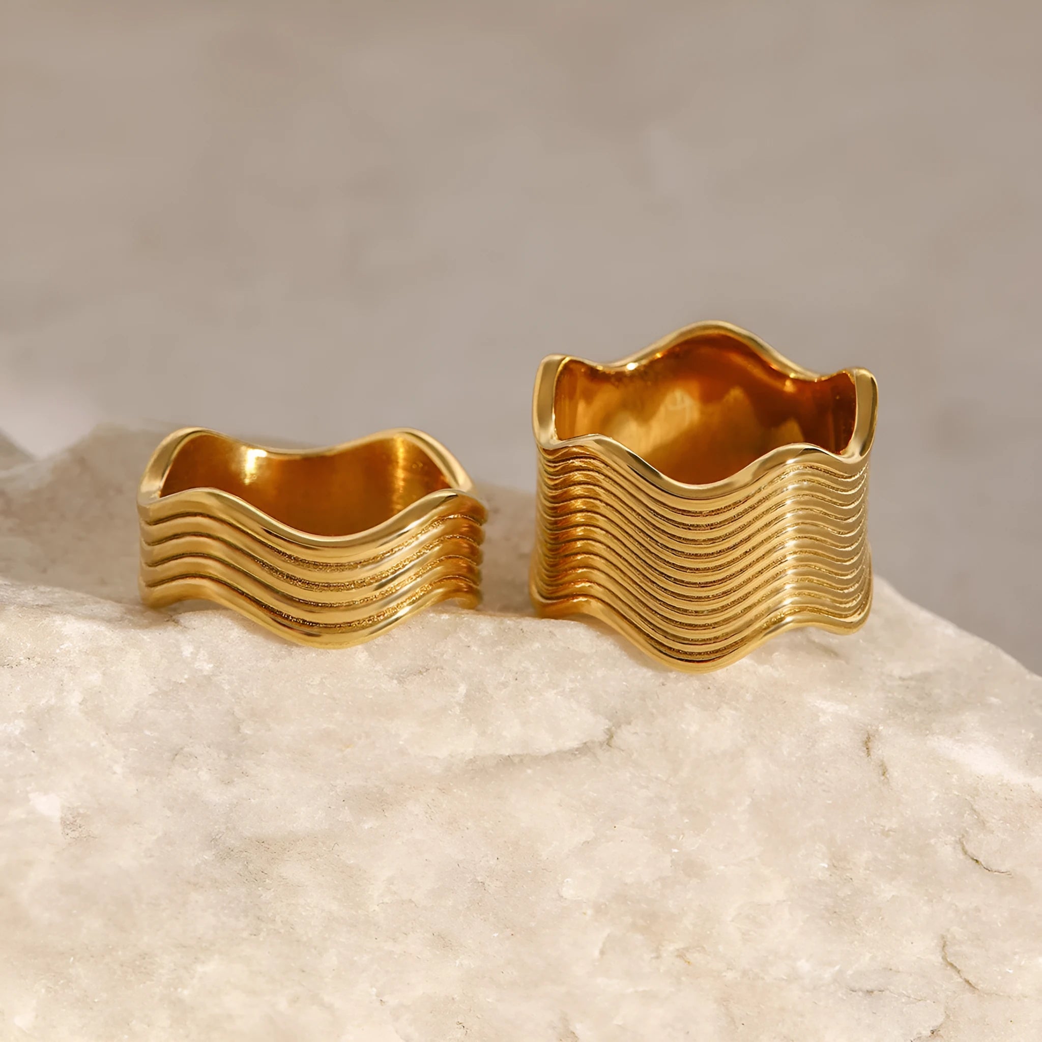 Stainless steel wide band ring with a geometric wave design in a Korean style.