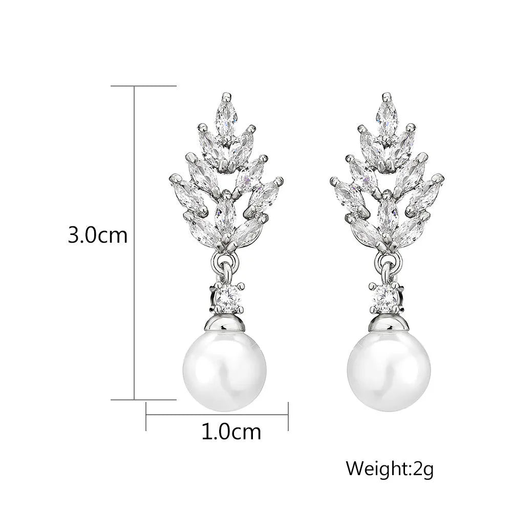 Geometric flower shaped earrings with micro inlaid zircon stones and pearl accents on a gold plated background.