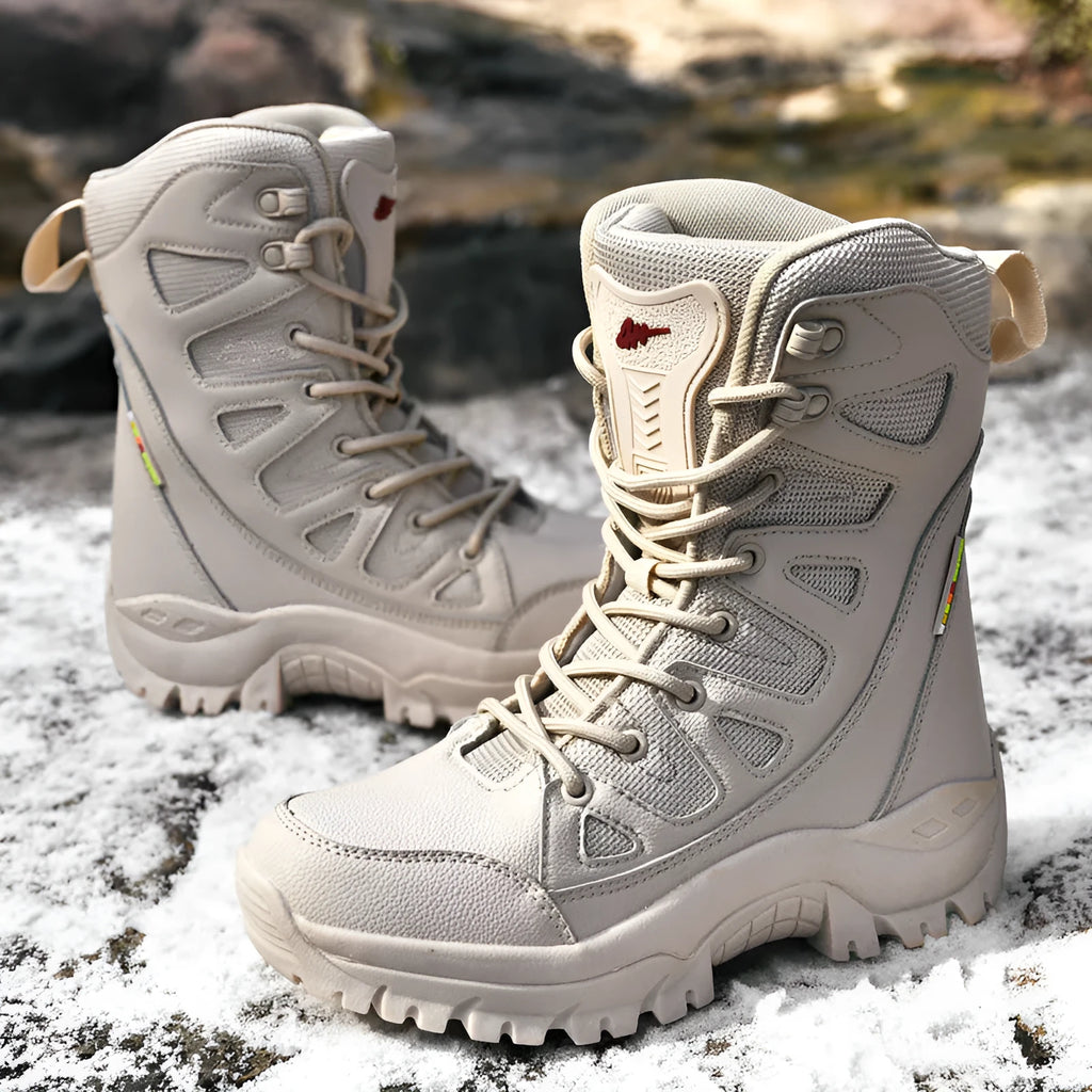 Men's beige cowhide leather hi-top hiking shoes with a platform sole on a rocky outdoor trail.