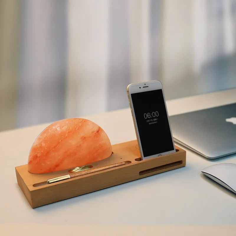 Sunrise Oriental table lamp with natural salt shade on wood base, showing wireless phone charging.