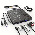 Black external USB CD/DVD burner drive on a desk next to a laptop