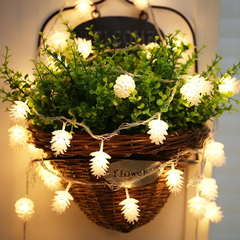 Battery-operated warm white LED string lights with pine cone shaped plastic shells.
