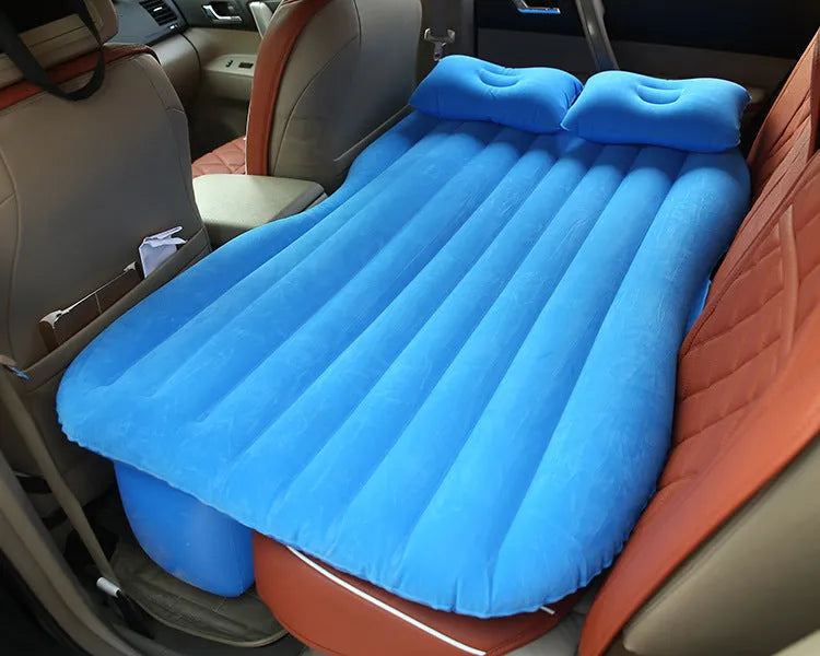 Black inflatable car bed with flocking material and two pillows, shown inside a car.