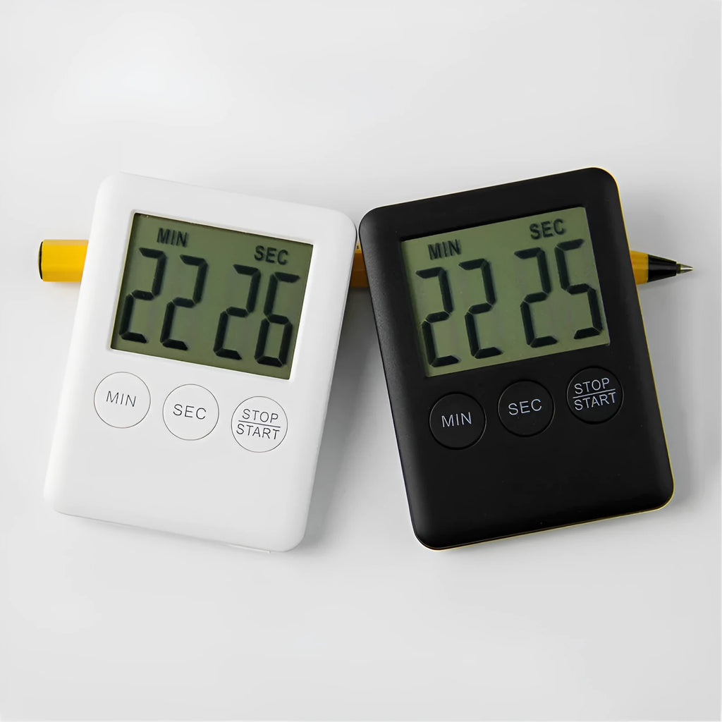 Black and white digital kitchen timer with magnetic back and display, shown on a refrigerator.