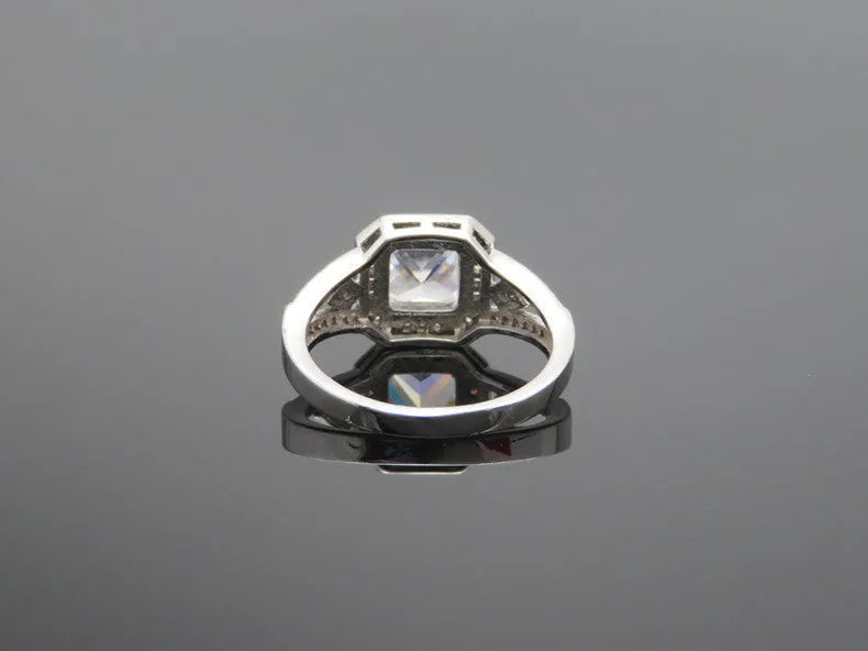 Platinum-colour zircon ring with hollow geometric quadrilateral design on a copper base