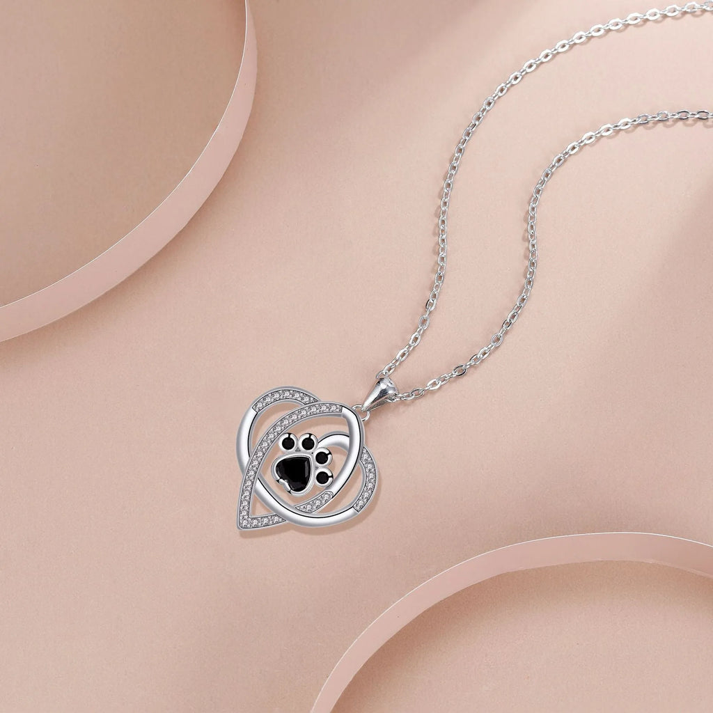 Close-up of a dog's paw print pendant necklace on a cross chain for women.