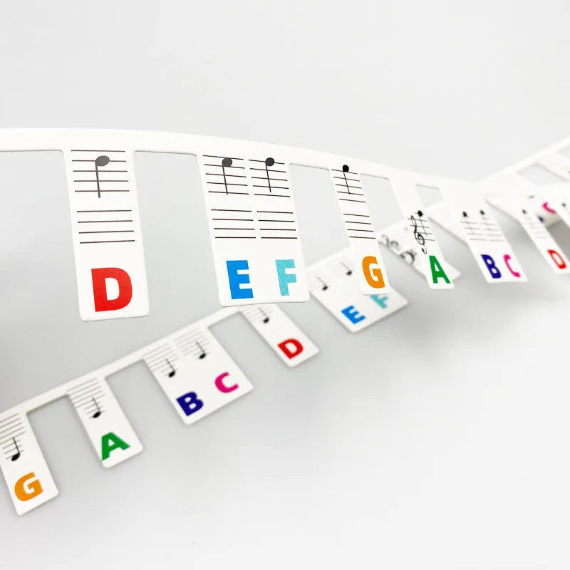 Piano keyboard stickers with colour note bars and black notes for 88-key learning on white card
