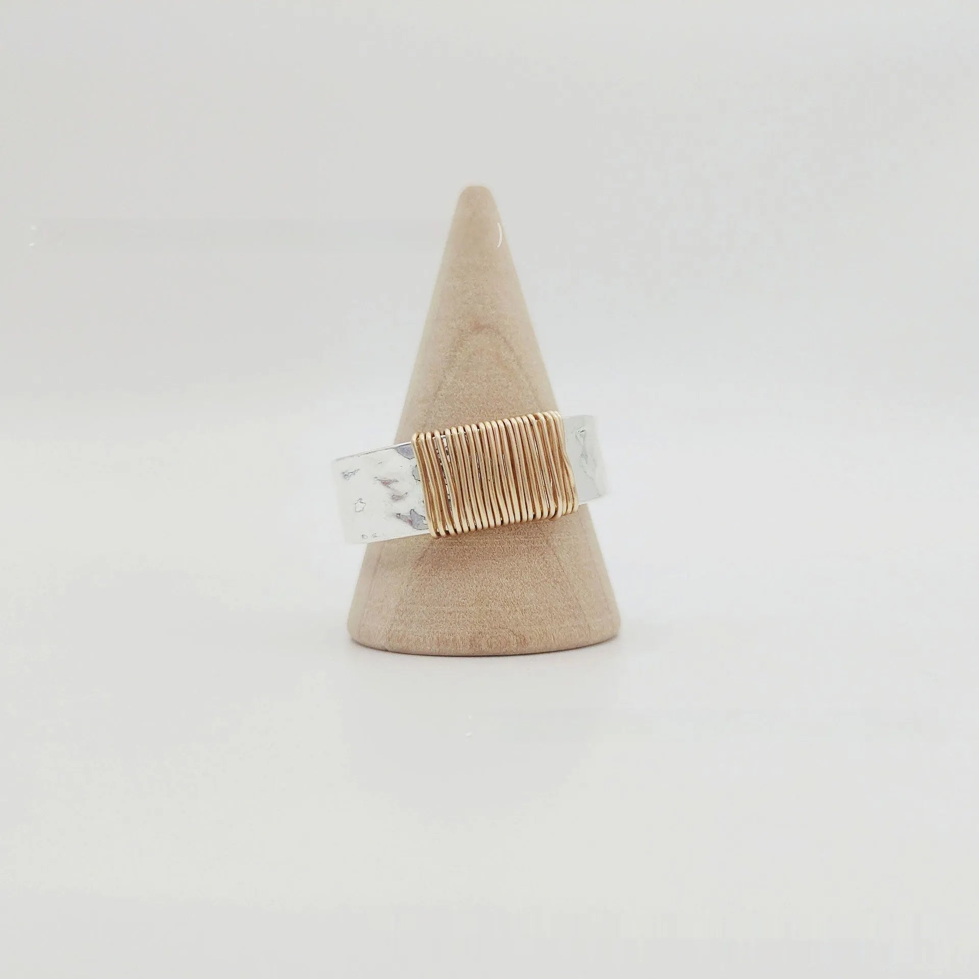 Geometric copper bracelet with irregular coil design and silver-gold electroplated finish.